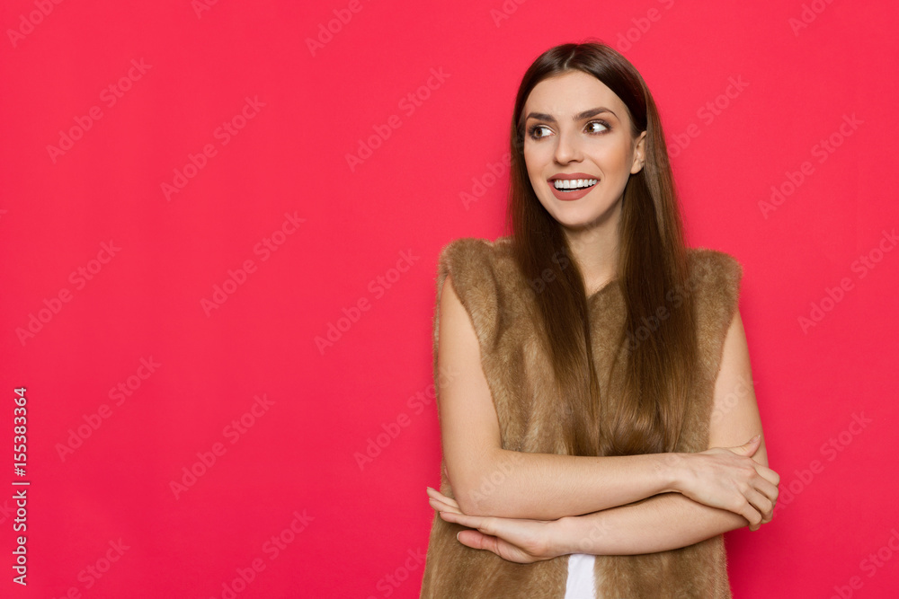 Young Smiling Woman In Fur Waistcoat Is Looking Away Young Smiling Woman In Fur Waistcoat Is Looking Away