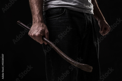 Male offender with a scrap. On black background at the studio