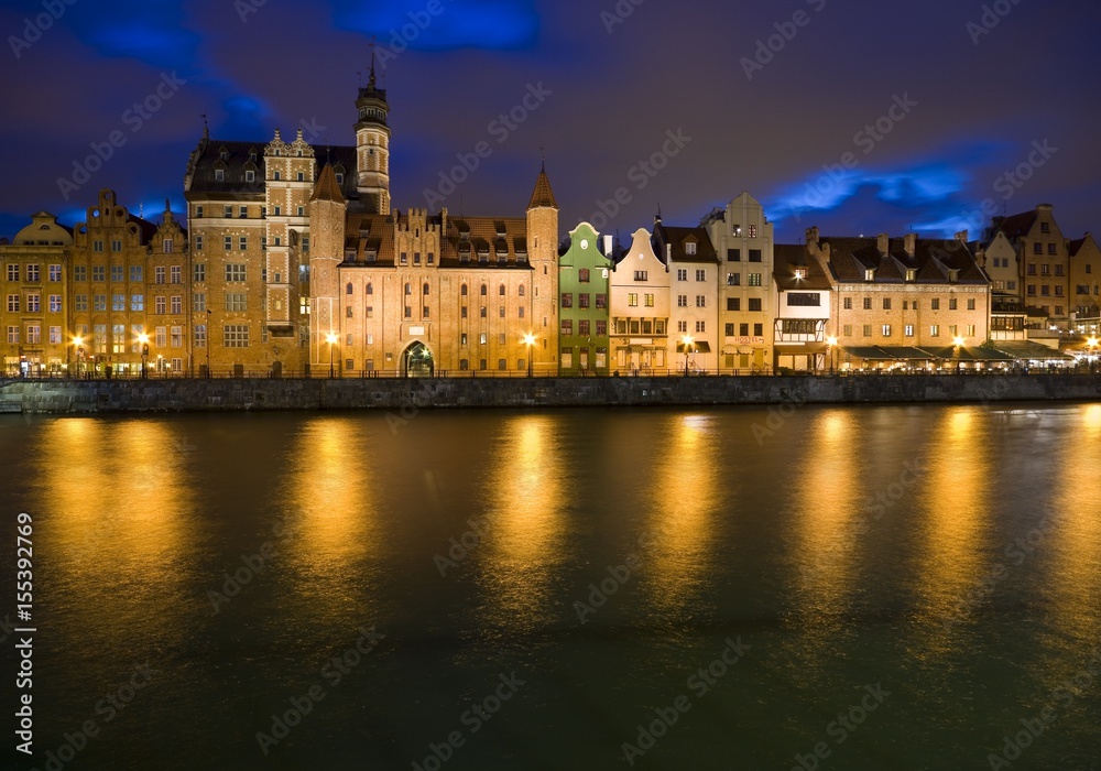 Long Embankment and Motlawa River in the Old Town of Gdansk, Poland at night. Mariacka Gate on the left
