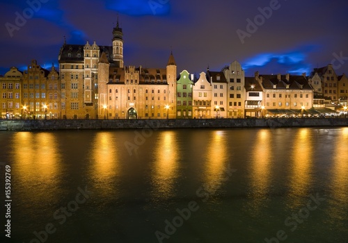 Long Embankment and Motlawa River in the Old Town of Gdansk, Poland at night. Mariacka Gate on the left