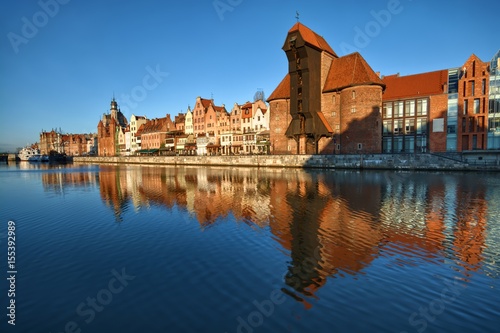 Long Embankment and Motlawa River in the Old Town of Gdansk, Poland at sunrise. Medieval port Crane - the most characteristic symbol of Gdansk on the right