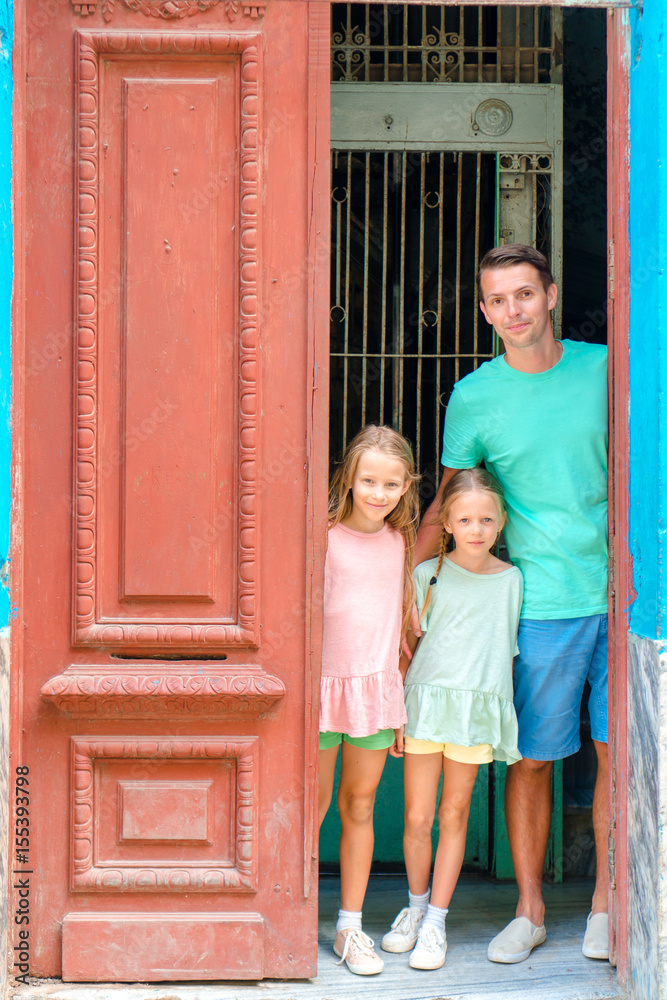 Obraz premium Portrait of happy family looking out door at old apartments in Havana