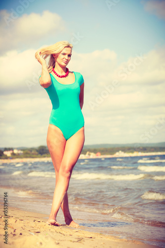 Woman walking on beach wearing swimsuit