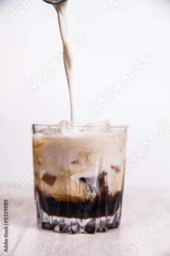 Preparation of white russian cocktails on the bar counter on rubber mat. Shallow DOF and marsala tonned