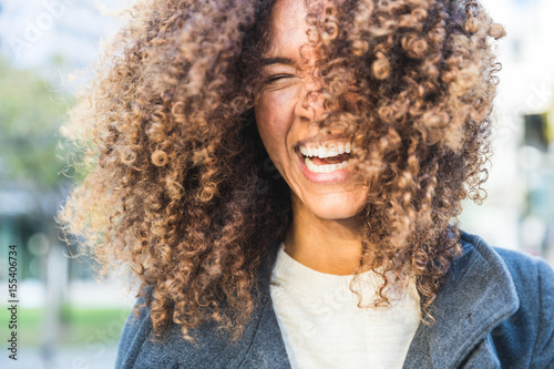 Curly woman laughing and shaking head