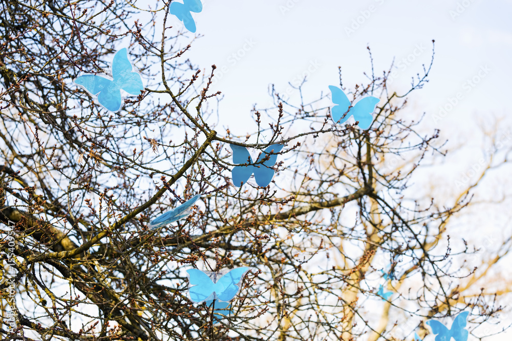 Spring tree and colorful artificial blue butterflies Spring tree and colorful artificial blue butterflies