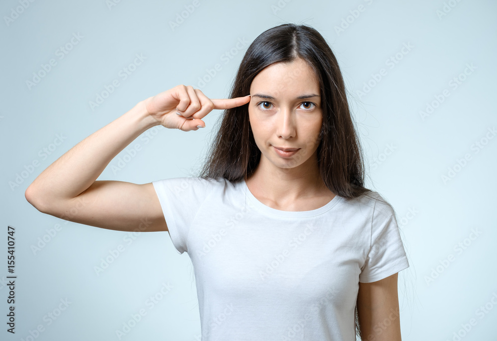 Are you crazy? Young beautiful woman gesturing finger against her temple Are you crazy? Young beautiful woman gesturing finger against her temple