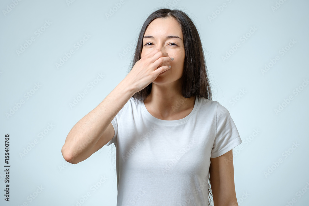 Girl covers nose with hand showing that something stinks Girl covers nose with hand showing that something stinks