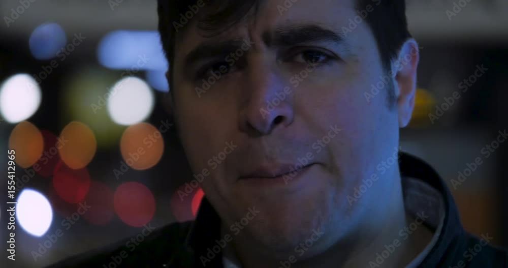 An extreme close up of a distraught man. The orbs of night lights are shining behind him as his eyes are about to begin tearing. An extreme close up of a distraught man. The orbs of night lights are shining behind him as his eyes are about to begin tearing.