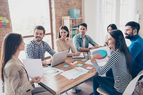 Team building concept. Meeting of colleagues, all of them are  in casual clothes, smiling and discussing the company`s development strategy at nice cozy  office photo