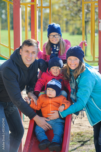 Happy smiling young family of five at children's playground in park © kaznadey