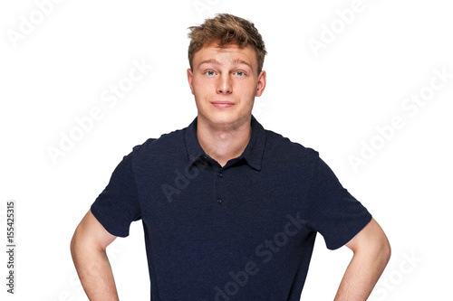 Man in navy polo t-shirt on white background with smile.