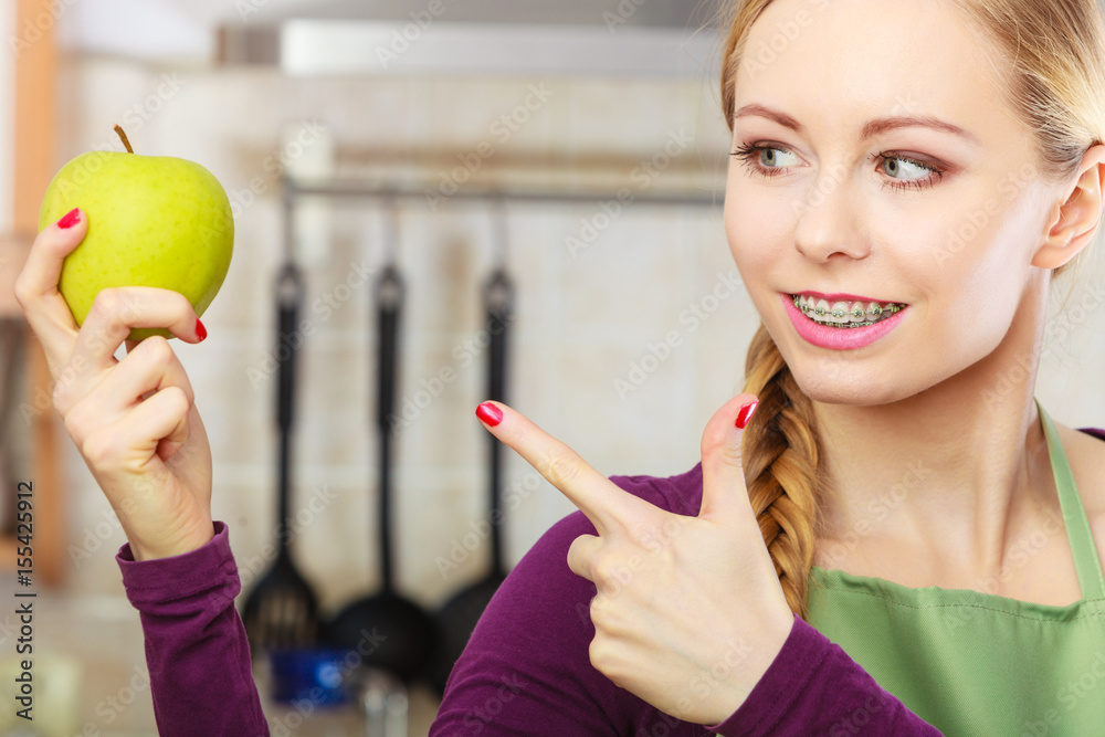 Woman young housewife in kitchen with apple fruit Woman young housewife in kitchen with apple fruit
