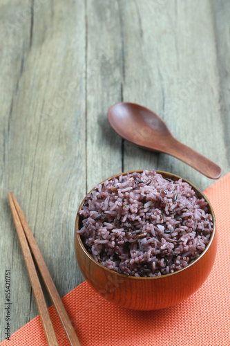 Organic Rice berry in wooden dish on wood background.