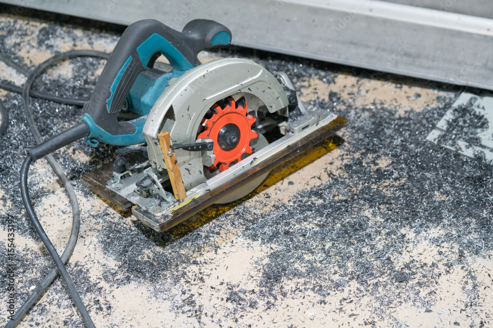 Circular electric saw on the concrete floor with iron powder 