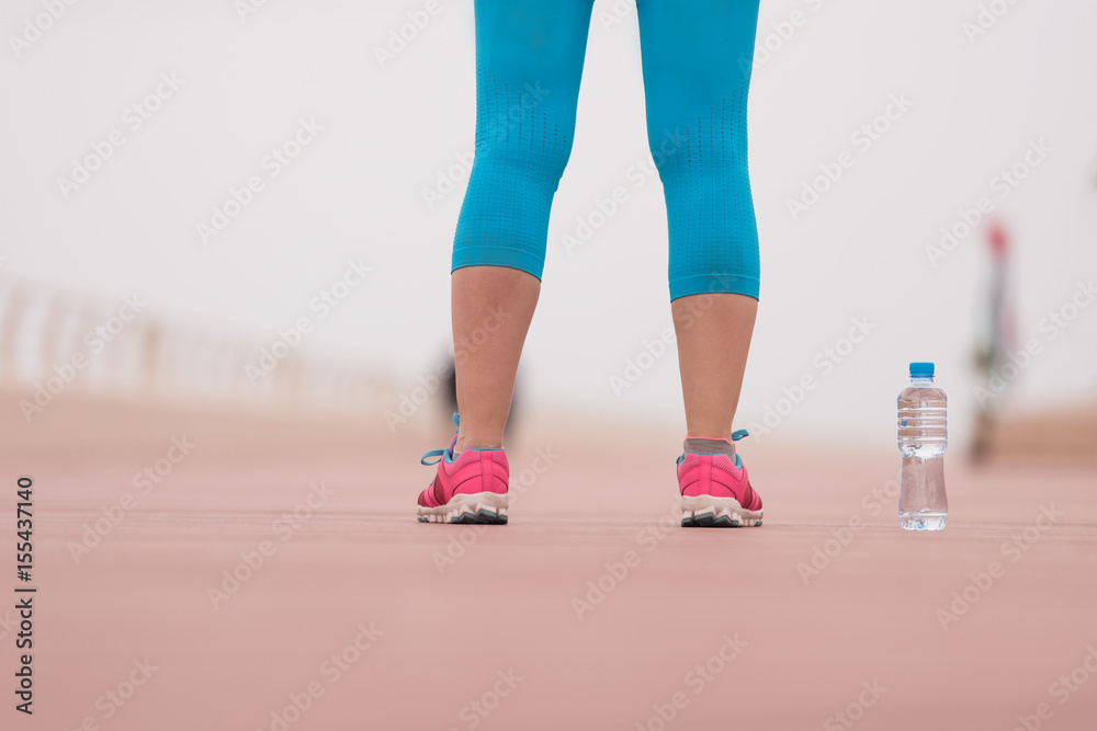 close up on running shoes and bottle of water