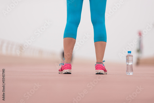 close up on running shoes and bottle of water