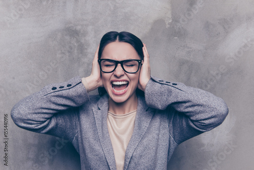 Bild auf Leinwand Close up of a stressed brunette woman yelling with closed eyes and ears