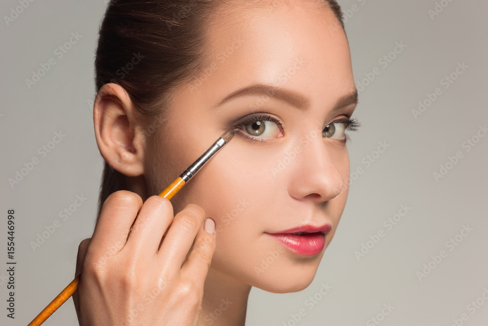 Beautiful female eyes with make-up and brush Beautiful female eyes with make-up and brush