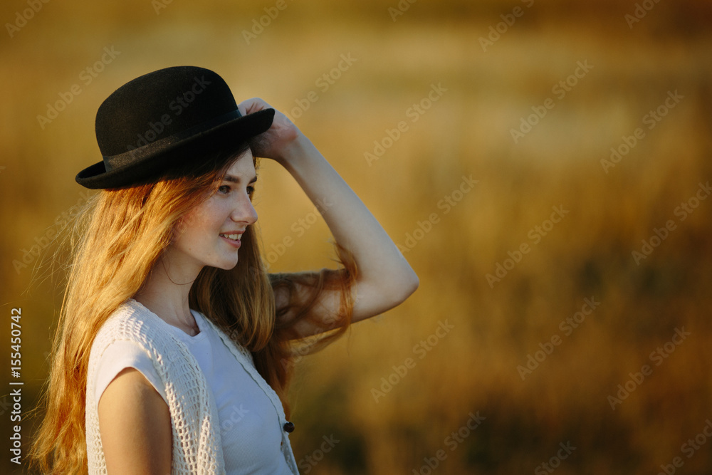 Close up portrait of young pretty woman wearing black hat outdoor on sunset Close up portrait of young pretty woman wearing black hat outdoor on sunset