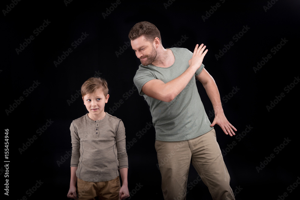Angry father threatening and gesturing to scared little son, family problems concept Angry father threatening and gesturing to scared little son, family problems concept