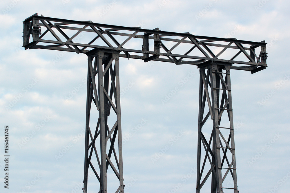 Top of electricity pylon against cloudy sky background Top of electricity pylon against cloudy sky background