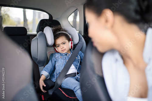little girl listening music in headphones while driving in car © LIGHTFIELD STUDIOS
