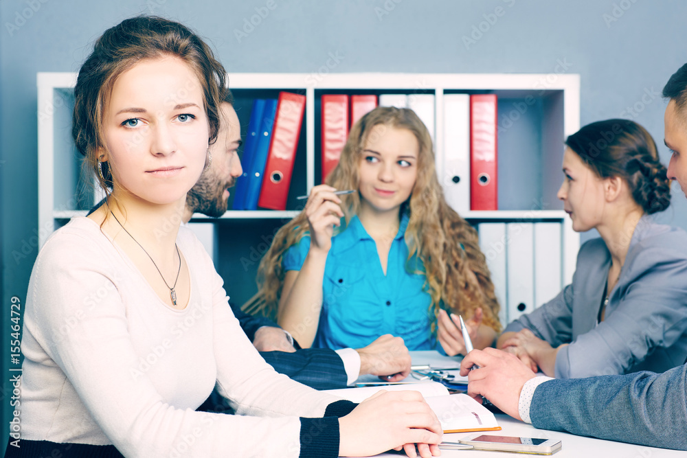 Female business leader sitting in front of her team. . Serious business and partnership concept. Female business leader sitting in front of her team. . Serious business and partnership concept.