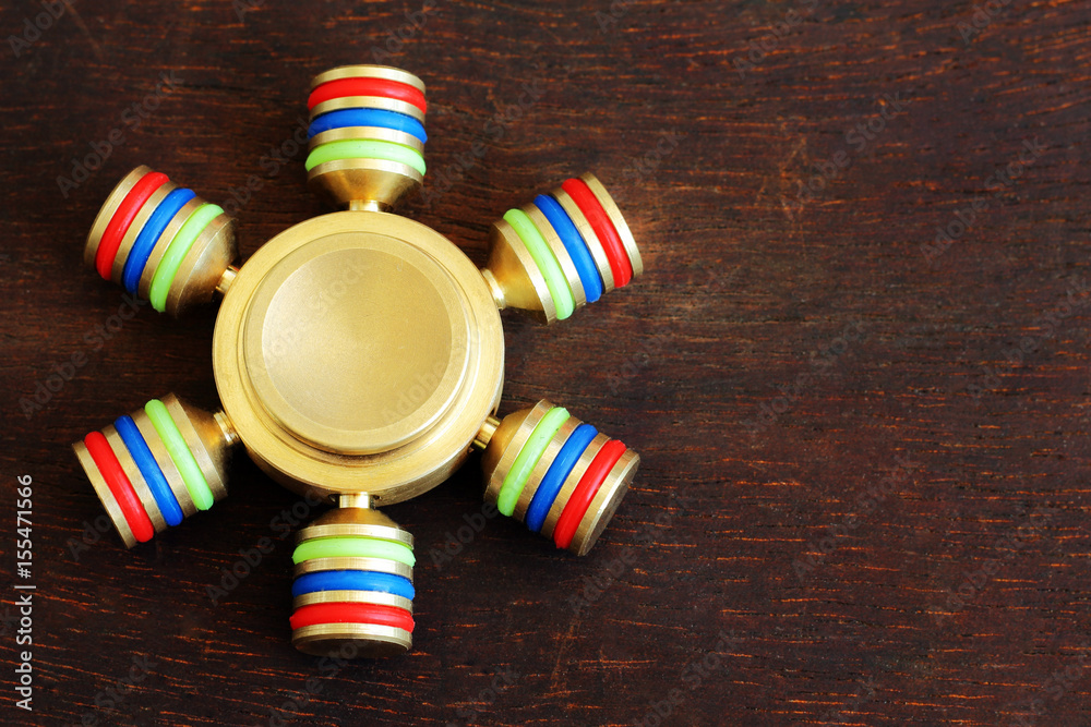 Gold fidget SPINNER stress relieving toy on wooden background. Israel MAY-23-2017. Gold fidget SPINNER stress relieving toy on wooden background. Israel MAY-23-2017.