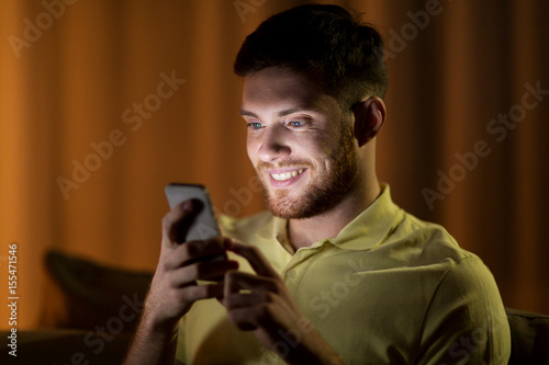 happy young man with smartphone at night