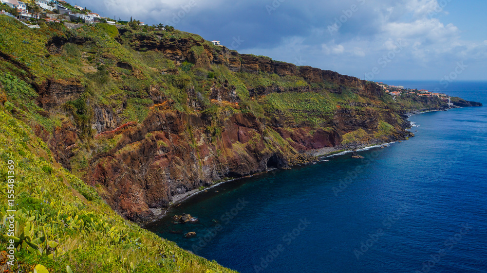 Madeira - Houses at the coast of Garajau with pride of madeira and cactusses and the blue ocean
