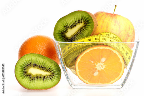 Fruit in transparent bowl: apple, orange and kiwi fruit halves