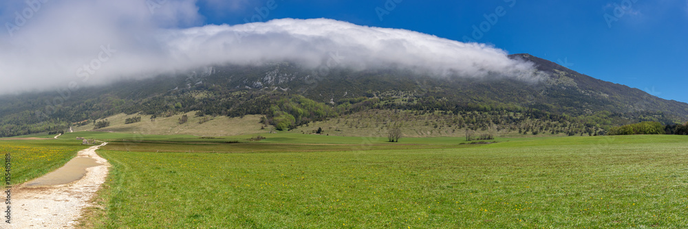 French countryside. Landscape on the plateau of Vercors with cloud formation in the mountains.