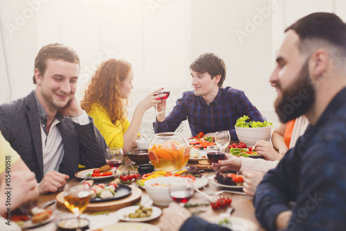 Group of happy people at festive table dinner party