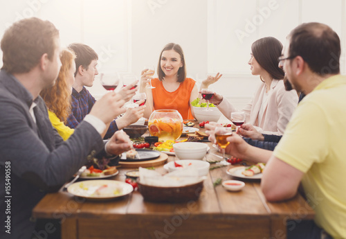 Group of happy people at festive table dinner party