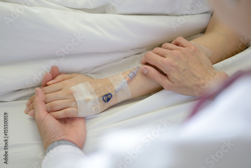 Medical doctor holing patient's hand and comforting her