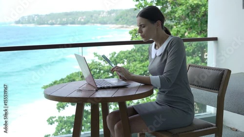 Wallpaper Mural Young businesswoman working with tablet and laptop sitting on terrace
 Torontodigital.ca