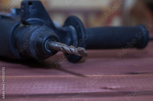 Hammer drill on a wooden background. Close-up. The electric tool