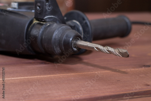 Hammer drill on a wooden background. Close-up. The electric tool