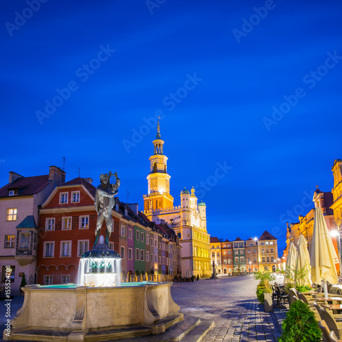 Night photo of Poznan Old Town with Apollo's fountain, beautifully decorated facade of the city hall and numerous highlighted townhouses.