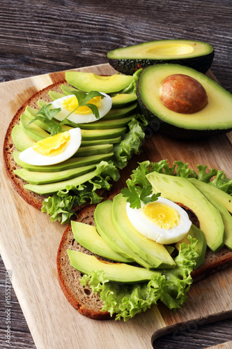 Sandwich with avocado and poached egg - healthy breakfast concept