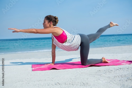 Full length of woman practicing yoga at beach