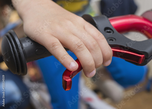 Close-up of a child s hand applying the brakes on a bicycle. Selective focus.