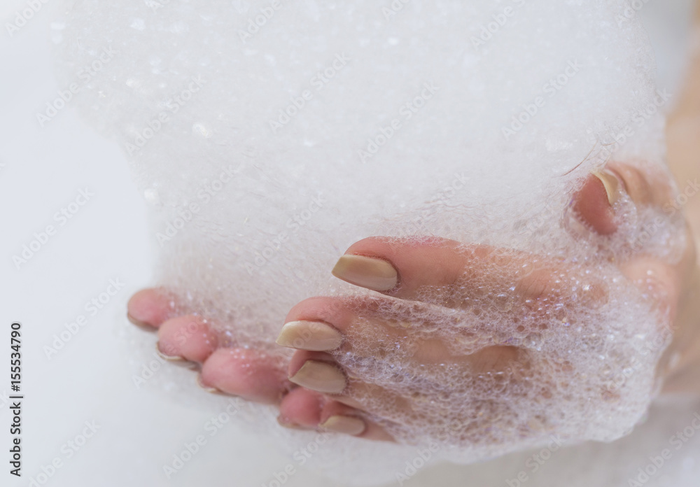 Fototapeta premium Beautiful female hands in white soap.