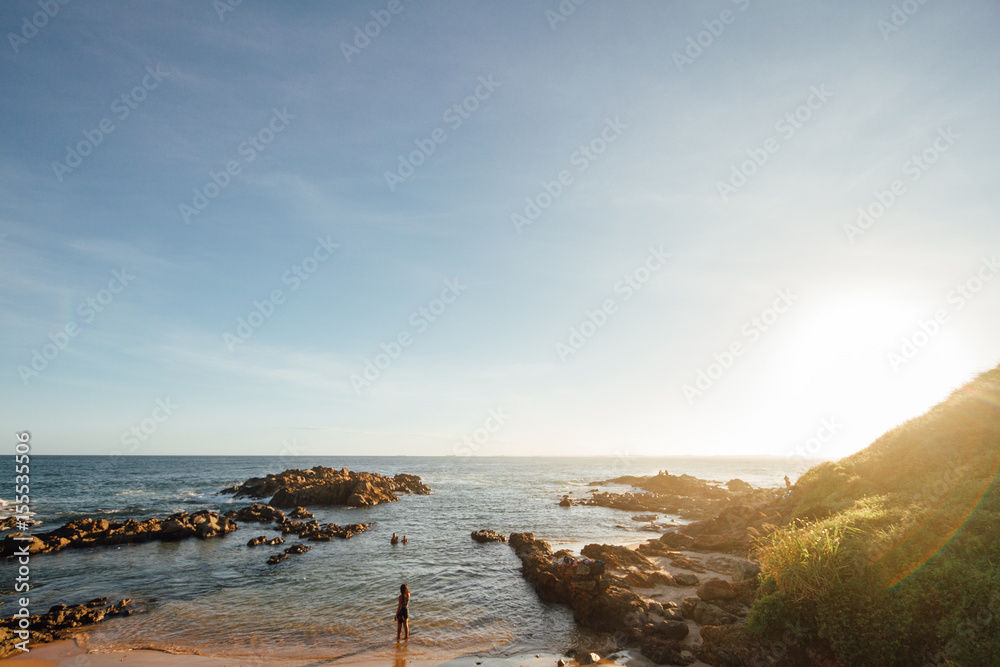 Φωτογραφία Woman on a beach among the rocks during sunset in Salvador de Bahia, Brazil