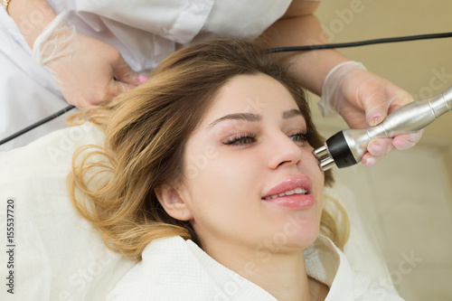 Beautiful young girl on the procedure of skin rejuvenation in the beauty salon