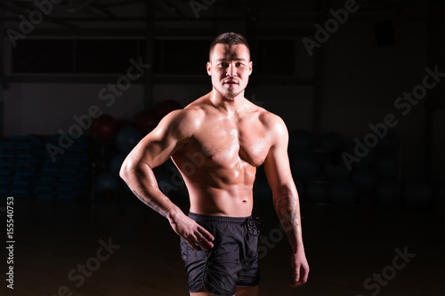 Strong Athletic Man Fitness Model Torso showing six pack abs in gym © satura_