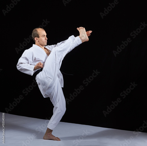 A kick on the arm the adult athlete is beating on a black background