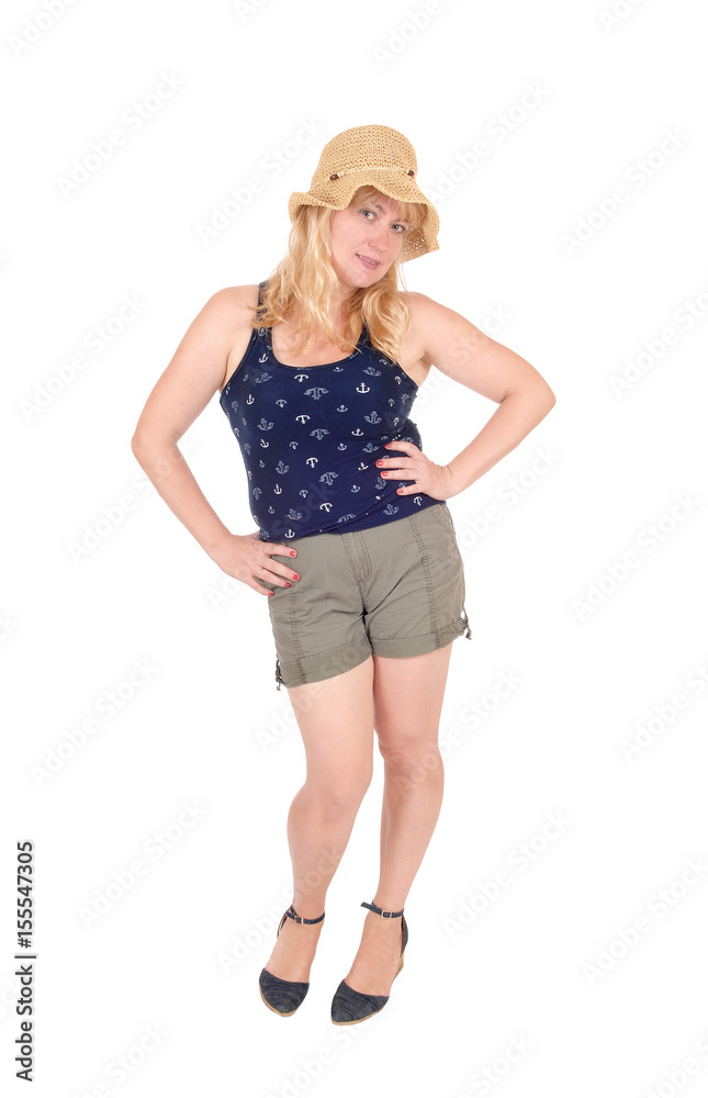 Woman standing in shorts and straw hat. Woman standing in shorts and straw hat.