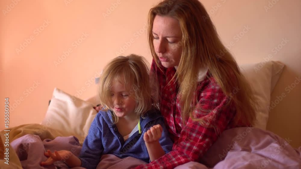 Happy family reading a book in the bed Happy family reading a book in the bed